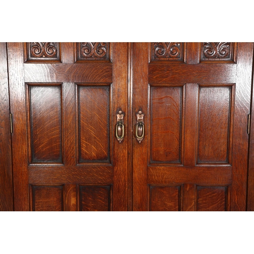 316 - AN ARTS & CRAFTS OAK HALL ROBE, having a moulded cornice above two foliate carved panels and four fu... 