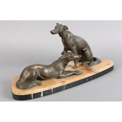 146 - AFTER DELORE AN ART DECO SPELTER FIGURE GROUP,  of a pair of lurchers seated and recumbent on a pink... 