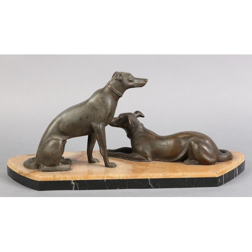 146 - AFTER DELORE AN ART DECO SPELTER FIGURE GROUP,  of a pair of lurchers seated and recumbent on a pink... 