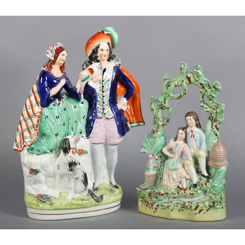 152 - A MID 19TH CENTURY STAFFORDSHIRE POTTERY FIGURE GROUP of a young man and girl sitting beneath a bowe... 