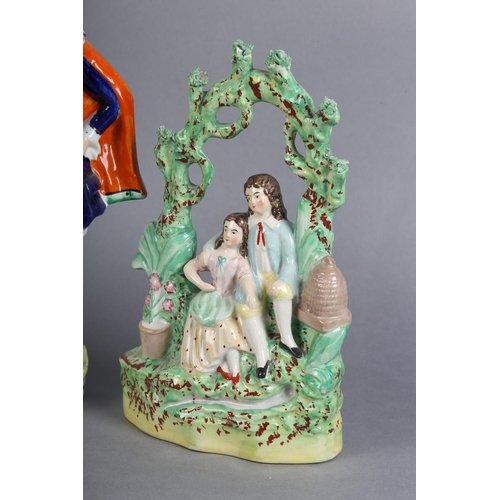 152 - A MID 19TH CENTURY STAFFORDSHIRE POTTERY FIGURE GROUP of a young man and girl sitting beneath a bowe... 