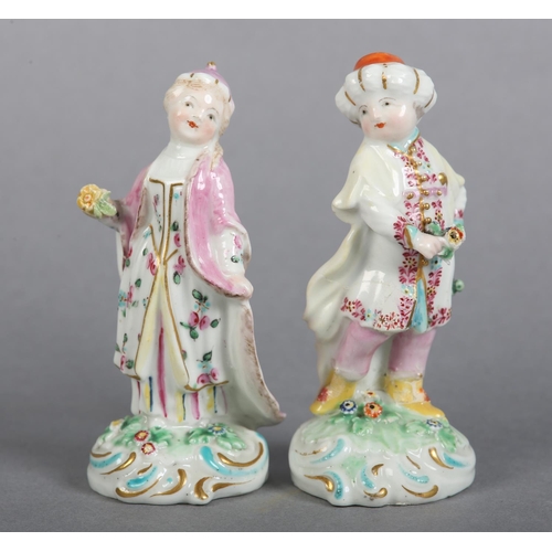 151 - A PAIR OF DERBY PORCELAIN FIGURES OF TURKS, male and female each on a flower strewn mound with 'C' s... 