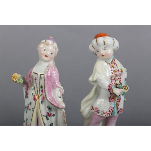 151 - A PAIR OF DERBY PORCELAIN FIGURES OF TURKS, male and female each on a flower strewn mound with 'C' s... 