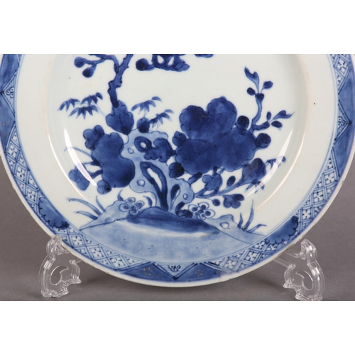 174 - AN 18TH CENTURY CHINESE BLUE AND WHITE PLATE painted with rocks issuing blossom within a diaper bord... 