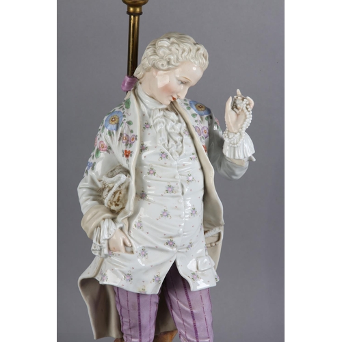 168 - A LATE 19TH CENTURY GERMAN PORCELAIN FIGURE OF A GENTLEMAN IN ELEGANT DRESS, proffering a string of ... 