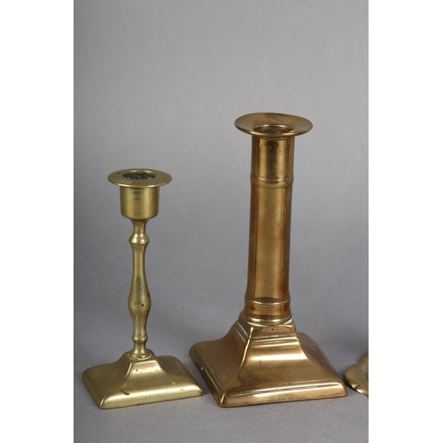 90 - A PAIR OF GEORGE III BRASS CANDLESTICKS with barrel-shaped nozzles, knopped stems on circular spread... 