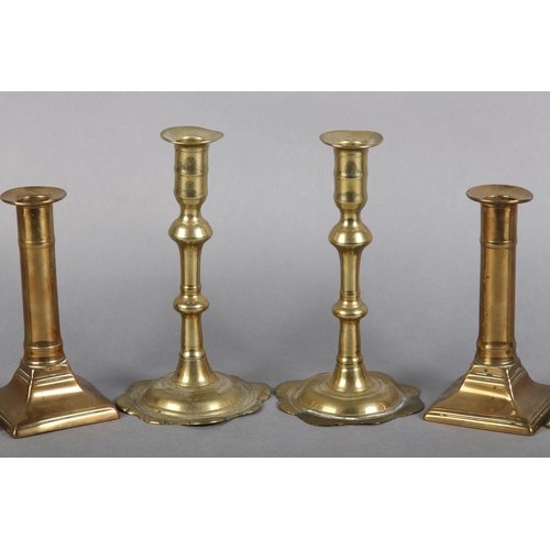 90 - A PAIR OF GEORGE III BRASS CANDLESTICKS with barrel-shaped nozzles, knopped stems on circular spread... 