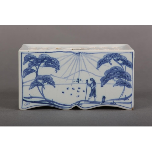 169 - AN ISIS POTTERY (OXFORD) TIN GLAZE DELFTWARE FLOWERBRICK painted in blue and white with a traveller ... 