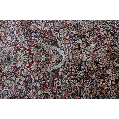 307 - A TABRIZ SILK CARPET, the dark blue field with urns of flowers flanked by flowering trees and birds,... 