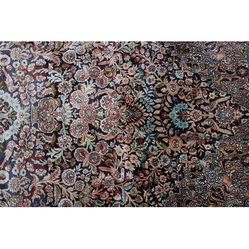 307 - A TABRIZ SILK CARPET, the dark blue field with urns of flowers flanked by flowering trees and birds,... 