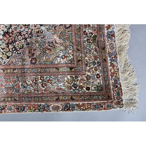 307 - A TABRIZ SILK CARPET, the dark blue field with urns of flowers flanked by flowering trees and birds,... 