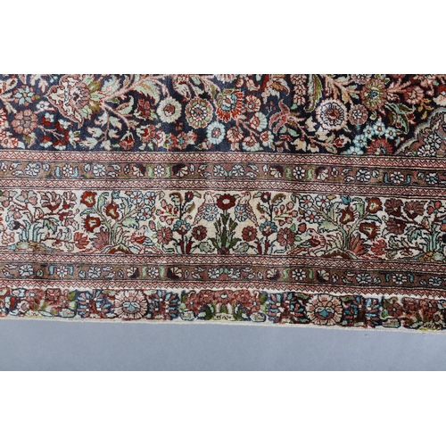 307 - A TABRIZ SILK CARPET, the dark blue field with urns of flowers flanked by flowering trees and birds,... 