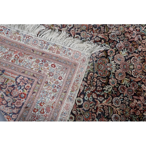 307 - A TABRIZ SILK CARPET, the dark blue field with urns of flowers flanked by flowering trees and birds,... 