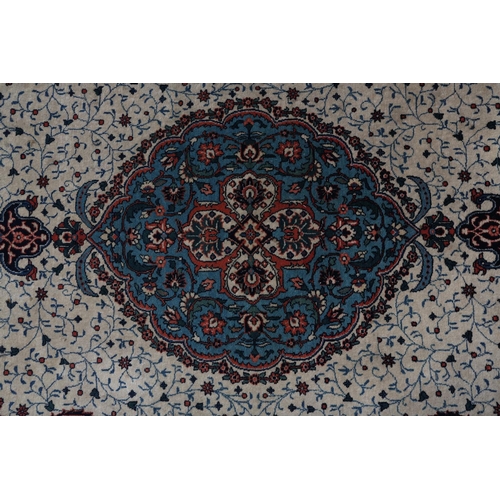 308 - A KASHAN CARPET, the ivory field having a central blue medallion filled with flowers, within a surro... 