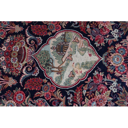 309 - A TABRIZ CARPET, the dark blue field having a pictorial landscape with Mosque to the central medalli... 