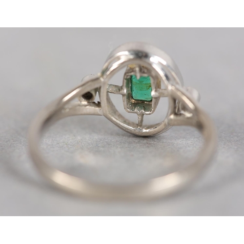 243 - AN ART DECO STYLE EMERALD AND DIAMOND THREE STONE RING in 18ct white and yellow gold by Ogden’s of H... 