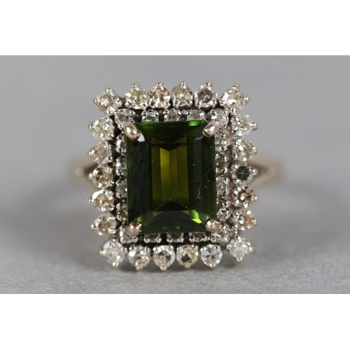 244 - A TOURMALINE AND DIAMOND CLUSTER RING c.1960, the step cut tourmaline claw set to the centre and rai... 