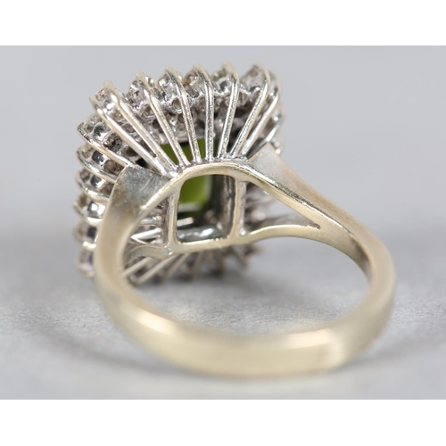 244 - A TOURMALINE AND DIAMOND CLUSTER RING c.1960, the step cut tourmaline claw set to the centre and rai... 