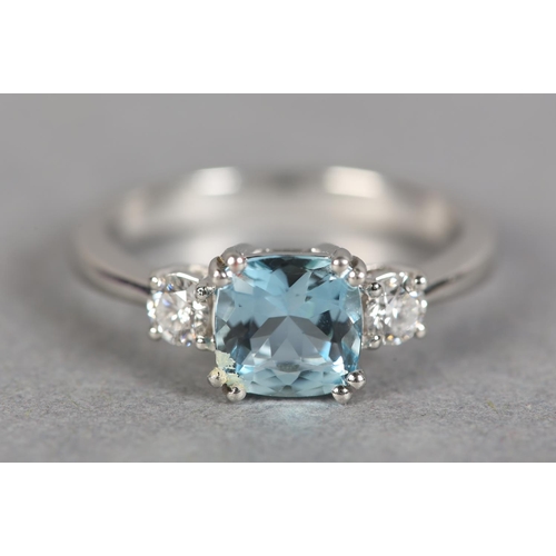 245 - AN AQUAMARINE AND DIAMOND THREE STONE RING in platinum, the square faceted aquamarine flanked by two... 