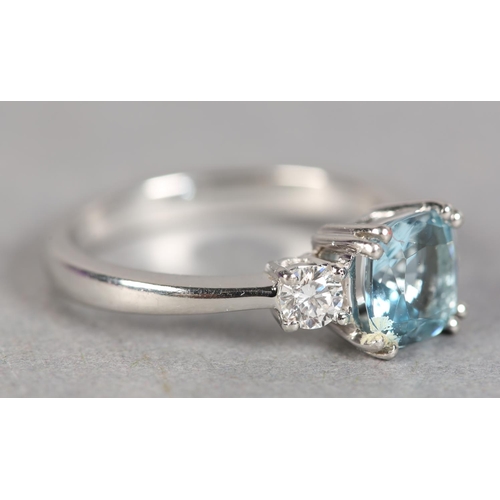 245 - AN AQUAMARINE AND DIAMOND THREE STONE RING in platinum, the square faceted aquamarine flanked by two... 