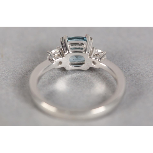 245 - AN AQUAMARINE AND DIAMOND THREE STONE RING in platinum, the square faceted aquamarine flanked by two... 