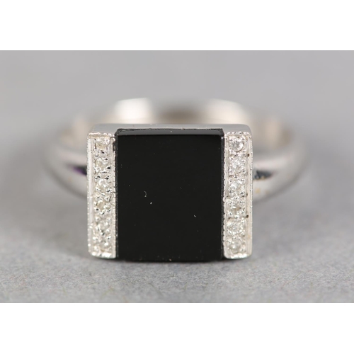 247 - AN ONYX AND DIAMOND ART DECO STYLE RING in 18ct white gold, the square onyx open seal, flanked by tw... 