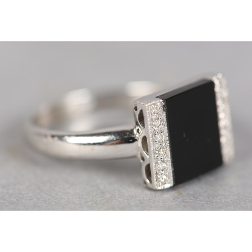 247 - AN ONYX AND DIAMOND ART DECO STYLE RING in 18ct white gold, the square onyx open seal, flanked by tw... 