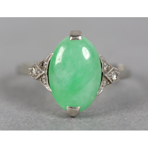 248 - A JADE AND DIAMOND DRESS RING in 18ct white gold, claw set with an oval cabochon stone flanked by si... 