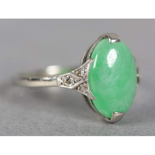 248 - A JADE AND DIAMOND DRESS RING in 18ct white gold, claw set with an oval cabochon stone flanked by si... 