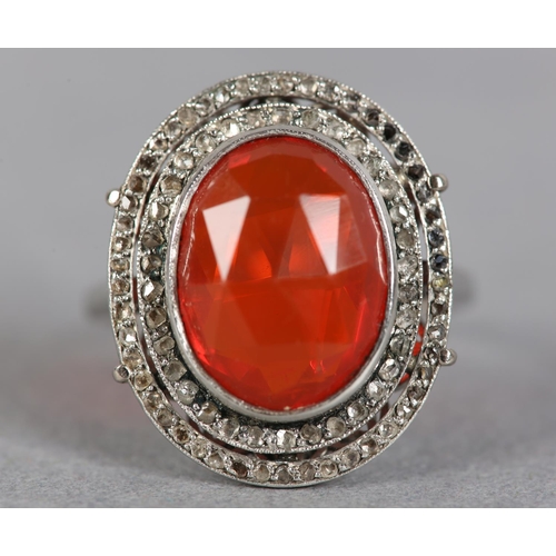 250 - AN ART DECO FIRE OPAL AND DIAMOND CLUSTER RING in platinum, collet set to the centre with an oval fa...