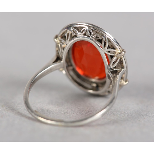 250 - AN ART DECO FIRE OPAL AND DIAMOND CLUSTER RING in platinum, collet set to the centre with an oval fa... 