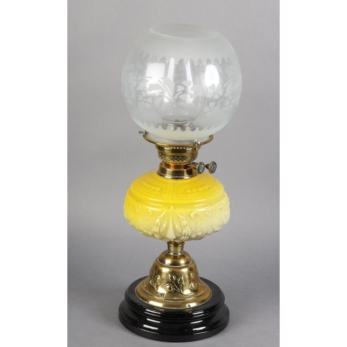 98 - A VICTORIAN BRASS OIL LAMP embossed with a band of plant forms, having a yellow tinted glass reservo... 