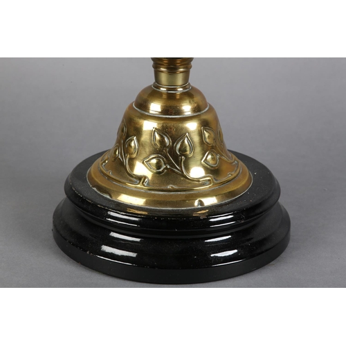 98 - A VICTORIAN BRASS OIL LAMP embossed with a band of plant forms, having a yellow tinted glass reservo... 