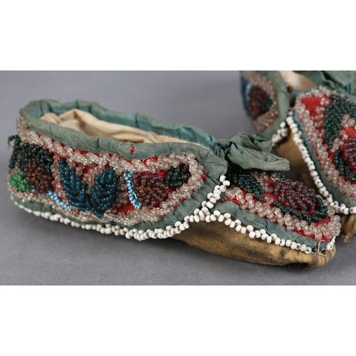 69 - A PAIR OF MID 19TH CENTURY CHILD'S BEADED SLIPPERS, worked in turquoise, teal, aubergine, green and ... 