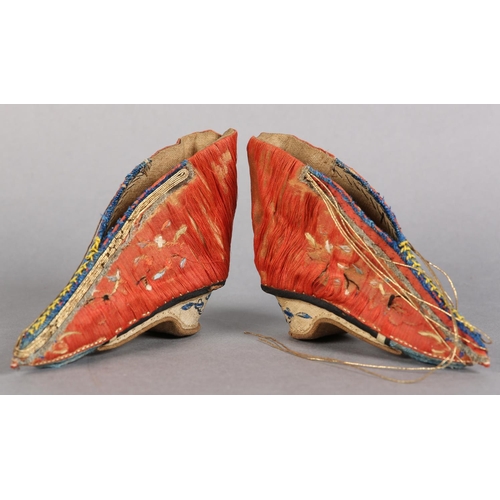 70 - A PAIR OF LATE 19TH CENTURY CHINESE LOTUS SHOES, embroidered silk, in deep coral worked with scatter... 