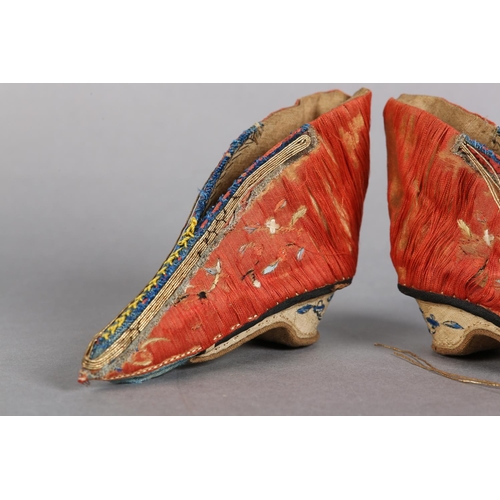 70 - A PAIR OF LATE 19TH CENTURY CHINESE LOTUS SHOES, embroidered silk, in deep coral worked with scatter... 