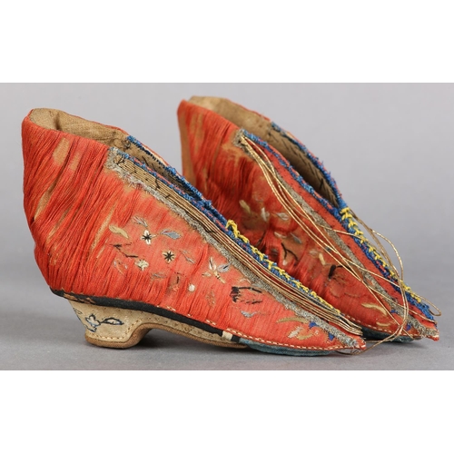 70 - A PAIR OF LATE 19TH CENTURY CHINESE LOTUS SHOES, embroidered silk, in deep coral worked with scatter... 