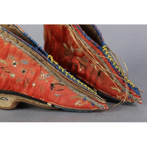 70 - A PAIR OF LATE 19TH CENTURY CHINESE LOTUS SHOES, embroidered silk, in deep coral worked with scatter... 