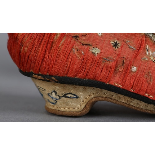 70 - A PAIR OF LATE 19TH CENTURY CHINESE LOTUS SHOES, embroidered silk, in deep coral worked with scatter... 