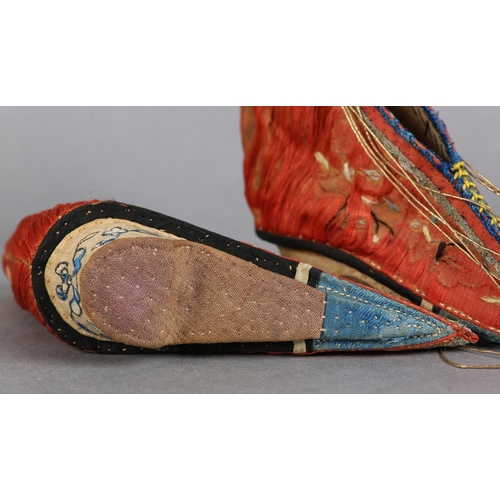 70 - A PAIR OF LATE 19TH CENTURY CHINESE LOTUS SHOES, embroidered silk, in deep coral worked with scatter... 