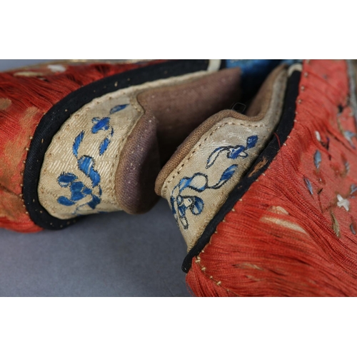 70 - A PAIR OF LATE 19TH CENTURY CHINESE LOTUS SHOES, embroidered silk, in deep coral worked with scatter... 