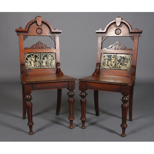 317 - A PAIR OF LATE 19TH CENTURY WALNUT HALL CHAIRS, the arched backs inset with tiles from the Minton Ea... 