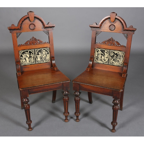 317 - A PAIR OF LATE 19TH CENTURY WALNUT HALL CHAIRS, the arched backs inset with tiles from the Minton Ea... 