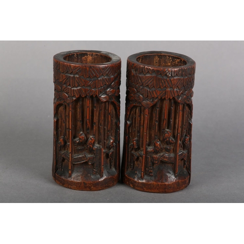 176 - A PAIR OF 19TH CENTURY BAMBOO BRUSH POTS, each carved in relief with figures amongst trees beneath a... 