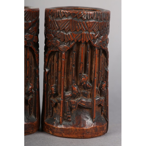 176 - A PAIR OF 19TH CENTURY BAMBOO BRUSH POTS, each carved in relief with figures amongst trees beneath a... 