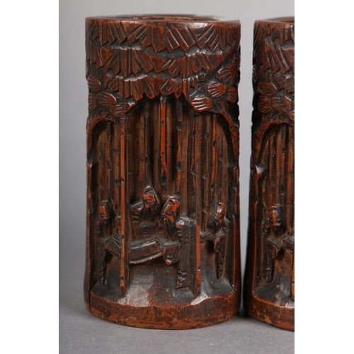 176 - A PAIR OF 19TH CENTURY BAMBOO BRUSH POTS, each carved in relief with figures amongst trees beneath a... 