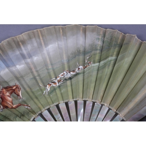 13 - A large late 19th century mother of pearl/burgau fan, boxed, the white gauze leaf painted with a hun... 