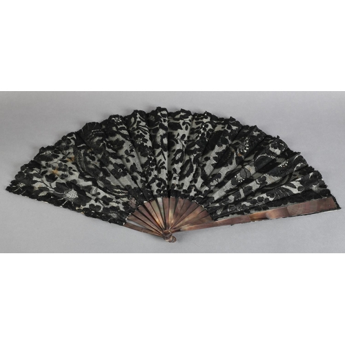 22 - A good late 19th century fan, the monture of Tahiti pearl, the leaf of black machine lace with a flo... 