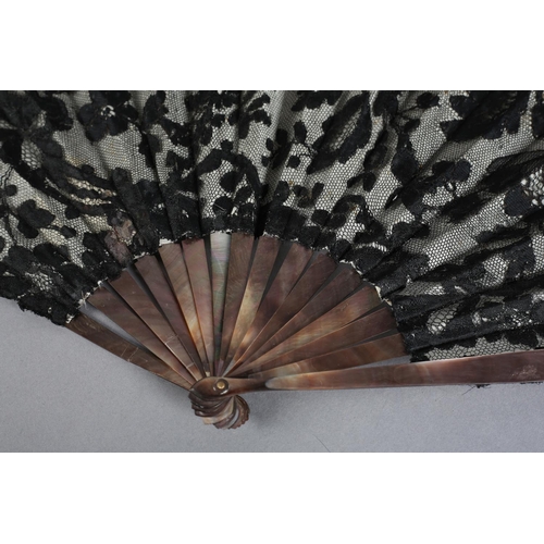 22 - A good late 19th century fan, the monture of Tahiti pearl, the leaf of black machine lace with a flo... 