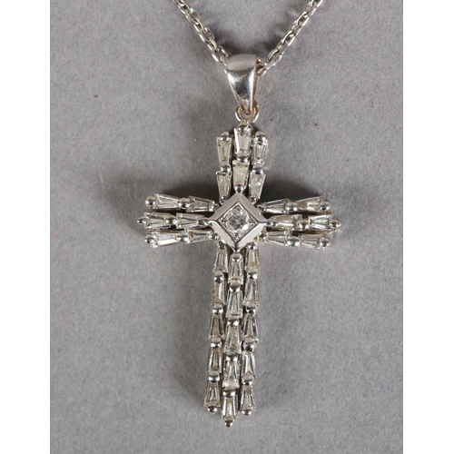 253 - A DIAMOND SET CROSS SET with tapered baggett cut stones with a single brilliant cut stone to the cen... 